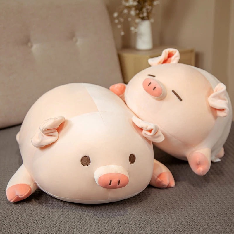 Two pink kawaii squishy piggy plushies, one with open eyes and one with closed eyes, stacked together on a couch.