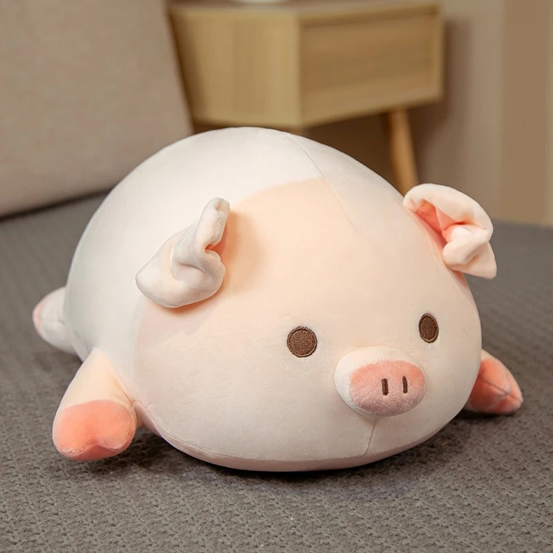A cute pink and white kawaii squishy piggy plush toy resting on a soft grey surface in a bedroom setting.