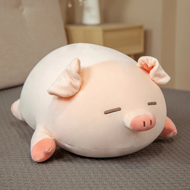 A cute sleeping pink and white kawaii squishy piggy plush toy resting on a soft grey surface in a bedroom setting.