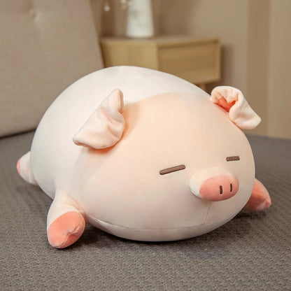 A cute sleeping pink and white kawaii squishy piggy plush toy resting on a soft grey surface in a bedroom setting.